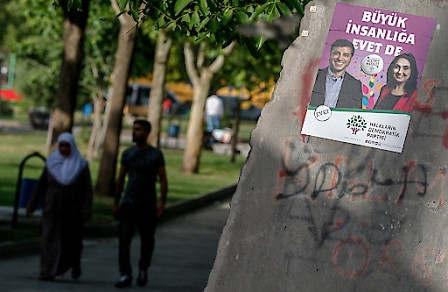 People walk near the poster of the Co-Chairs of the Peoples' Democratic Party (HDP) Figen Yuksekdag (R) and Selahattin Demirtas in Diyarbakir, Turkey, 